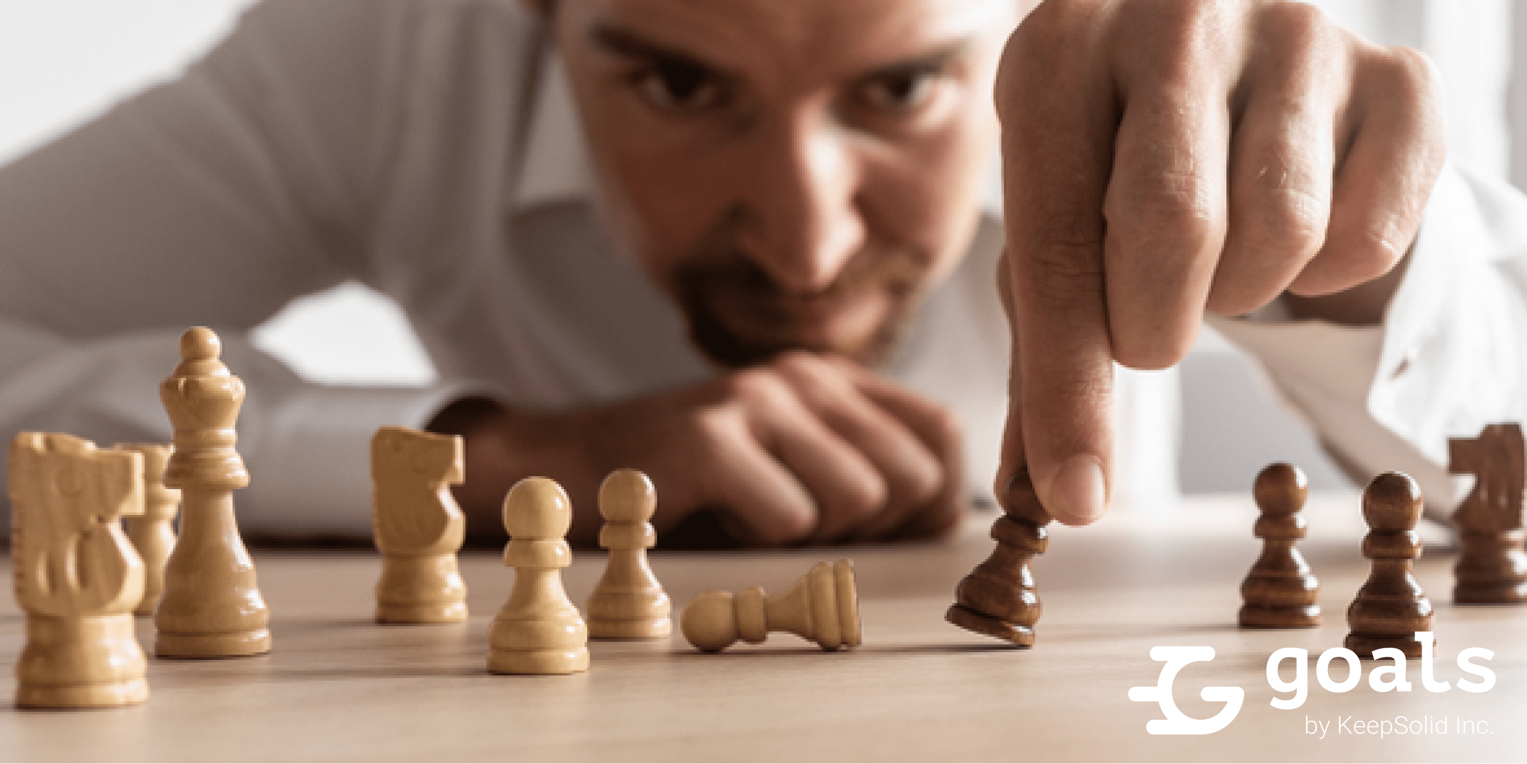 Businessman brainstorming as he creates business strategy by placing black and white chess pieces on an office desk, concept of bridging gaps with Goals app