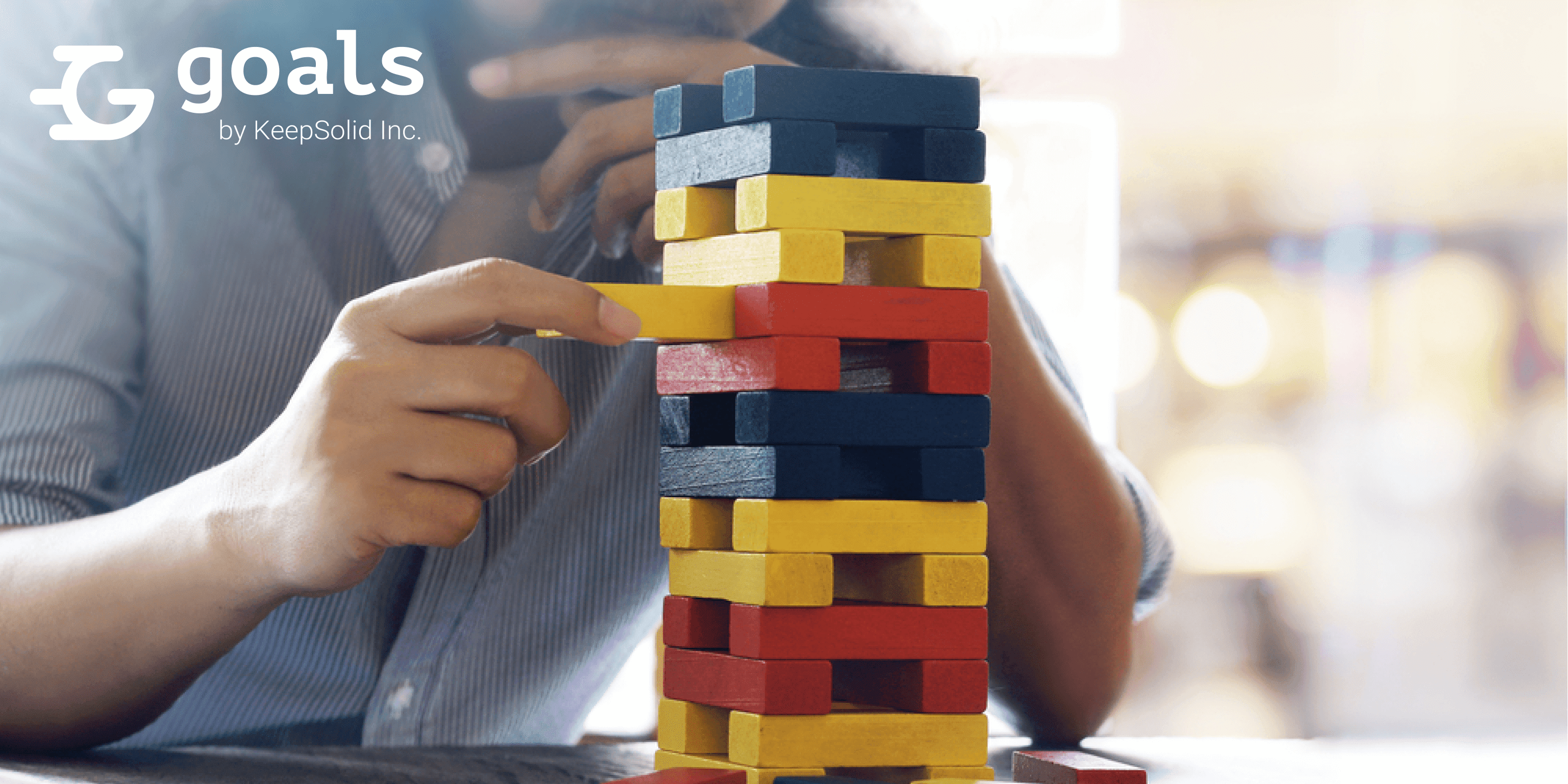 Male hand placed on a tower of wooden blocks on the table concept and strategic planning