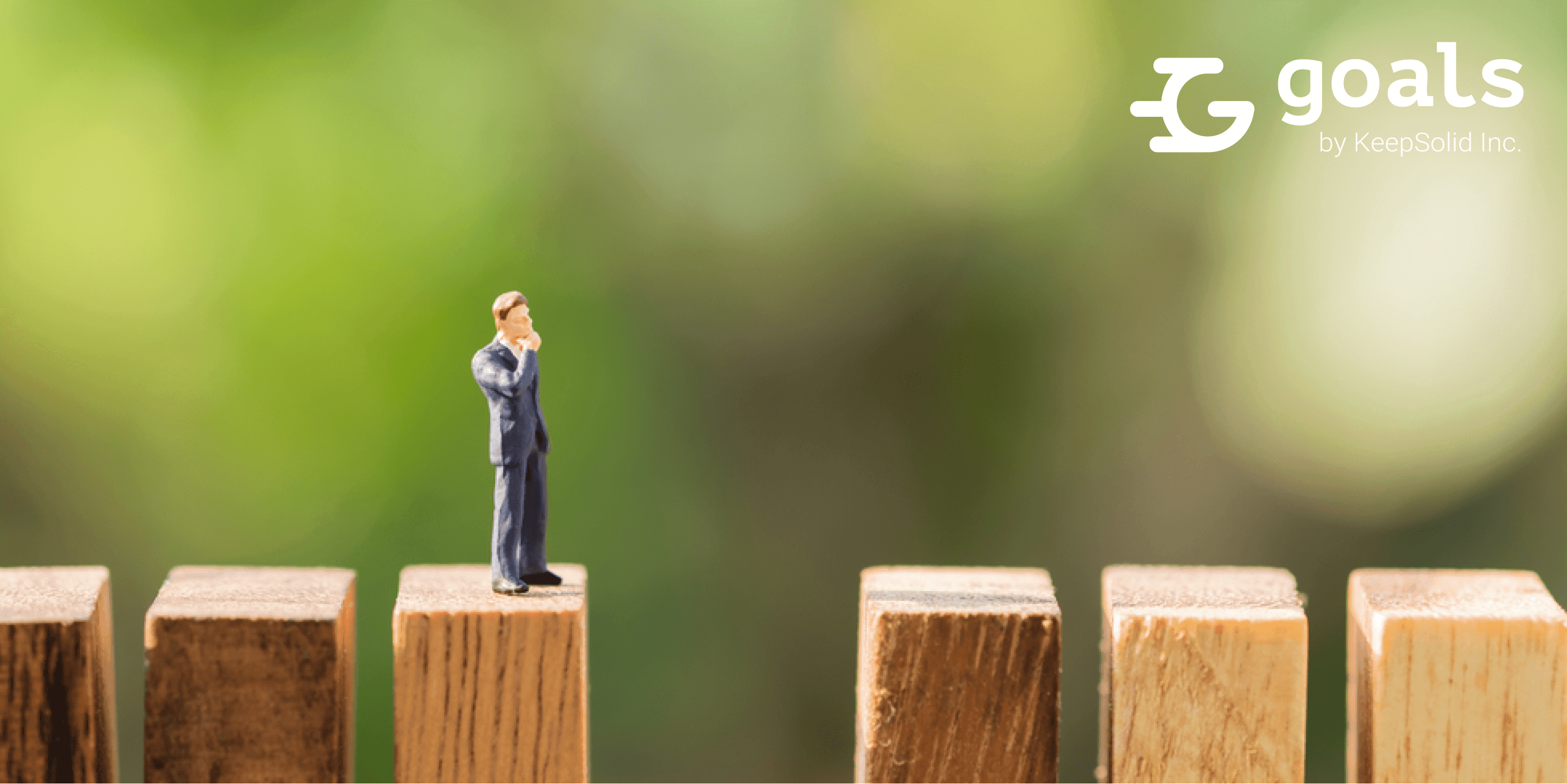Business and risk management concept. Businessman miniature figure standing on top of rows of made from wooden block looking and thinking about a lost block with green nature background